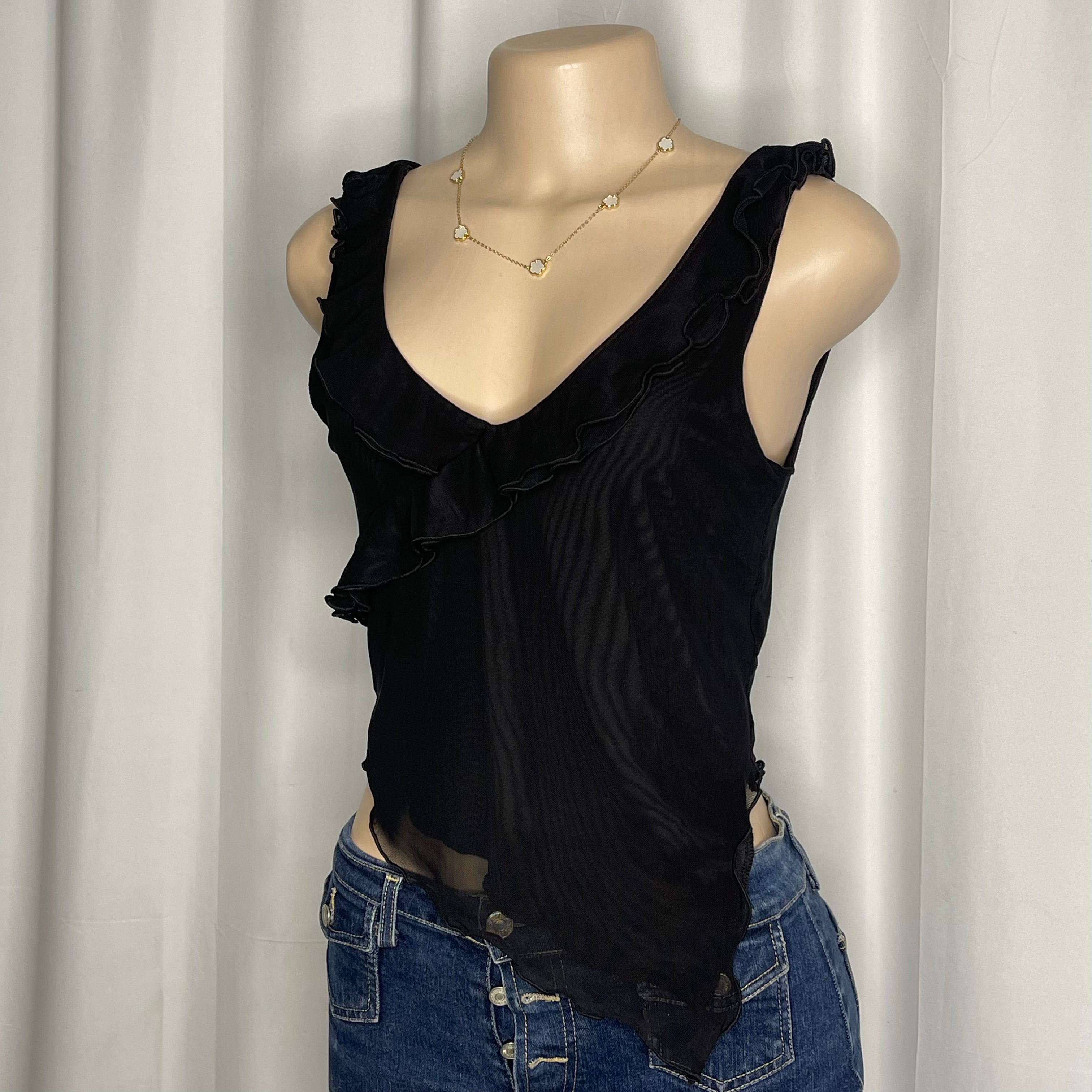 Black v-neck short blouse with ruffled trim and sheer asymmetrical hem
