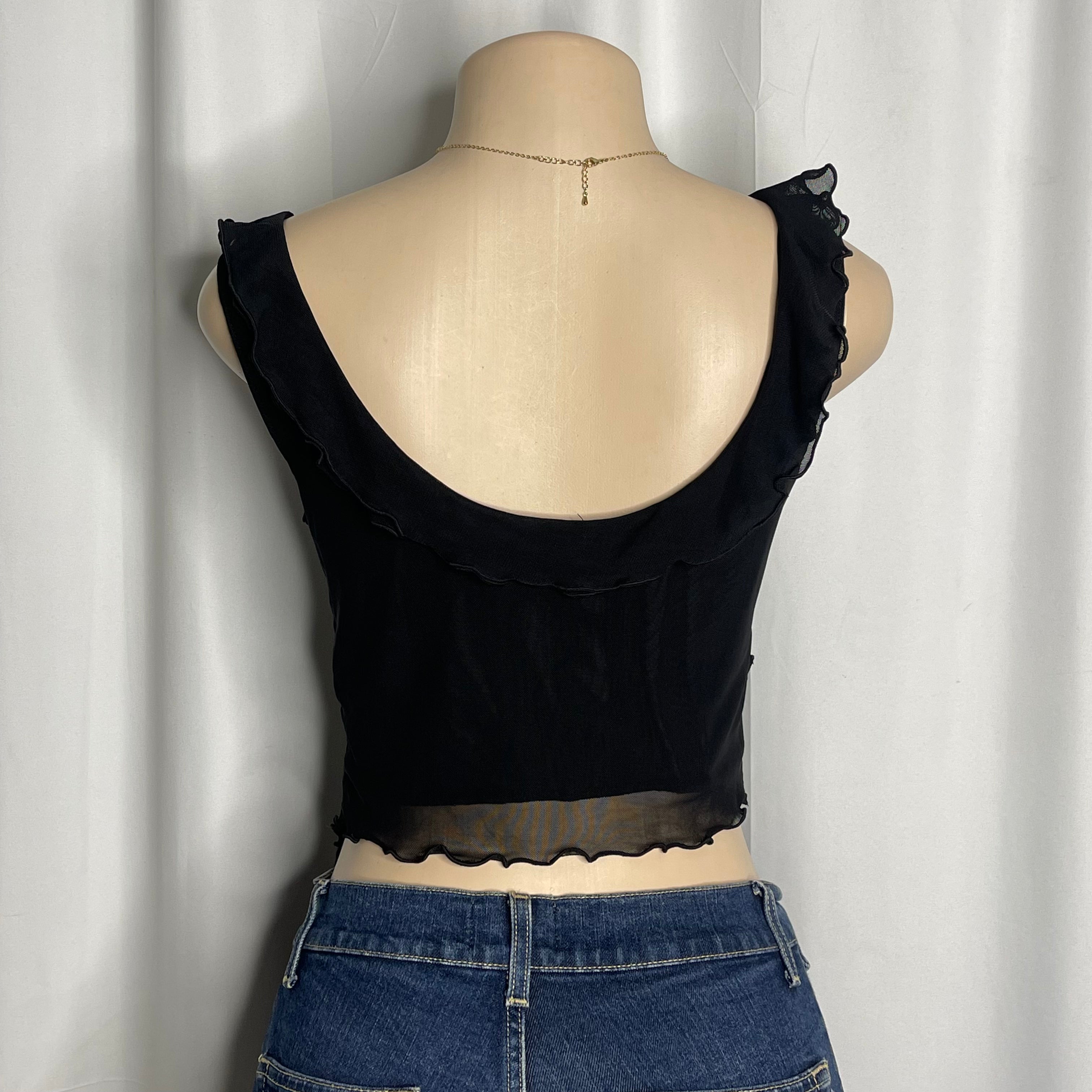 Black v-neck short blouse with ruffled trim and sheer asymmetrical hem